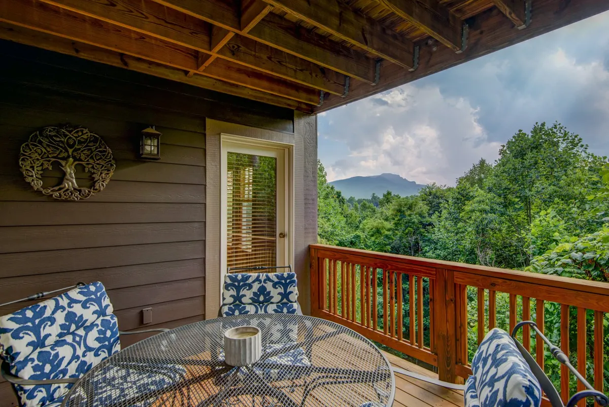 An exterior deck scene with a table and blue floral chairs, offering a panoramic mountain view—the perfect spot for morning coffee or evening relaxation as described in the section.